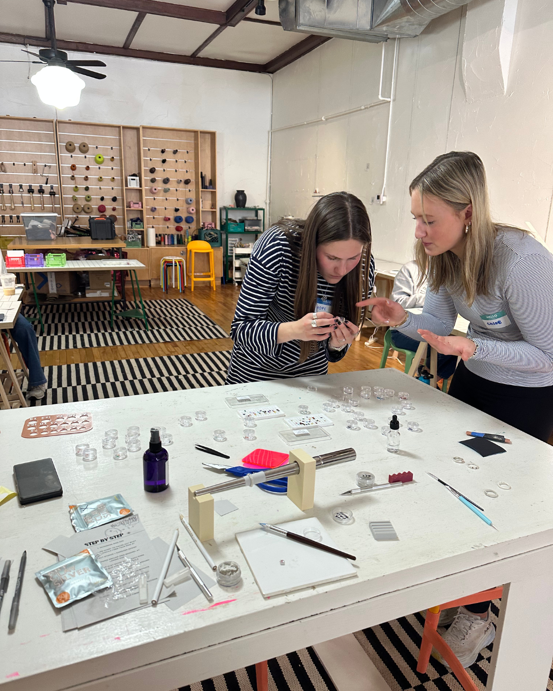 Two women picking stones at a ring jewelry workshop at Kaleidoscope Collective in downtown Rogers, Arkansas in their art studio space